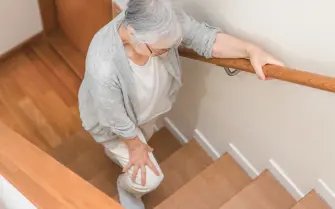 Anziano con dolore al ginocchio mentre scende le scale